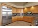 Kitchen with light wood cabinets, granite counters and backsplash, and stainless steel refrigerator at 15600 E Robin Dr, Fountain Hills, AZ 85268