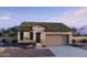 Charming single-story home with a neutral stucco facade, a green tile roof, and a manicured front yard with desert landscaping at 15611 W Hackamore Dr, Surprise, AZ 85387