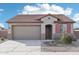 Charming single-story home with a tile roof, two-car garage, neutral stucco, and tasteful landscaping at 15611 W Hackamore Dr, Surprise, AZ 85387