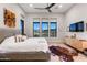 This spacious bedroom features a ceiling fan, three large windows, and a unique hide rug on wood floors at 16134 E Ridgestone Dr, Fountain Hills, AZ 85268