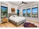 This bedroom features a neutral color palette, hardwood floors, a large bed, and three well-lit windows at 16134 E Ridgestone Dr, Fountain Hills, AZ 85268