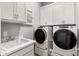 Bright laundry room with modern white cabinets, sink and Whirlpool washer and dryer at 16134 E Ridgestone Dr, Fountain Hills, AZ 85268