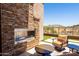 Outdoor seating area with stacked stone fireplace, lounge chairs, and desert views at 16134 E Ridgestone Dr, Fountain Hills, AZ 85268