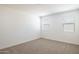 Comfortable bedroom with plush carpeting and natural light from two large windows at 17734 W Turquoise Ave, Waddell, AZ 85355