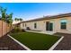 The backyard has artificial turf, an outdoor kitchen, a patio, and desert landscaping at 18371 W Roma Ave, Goodyear, AZ 85395
