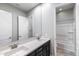 A bathroom featuring double sinks, a large mirror, and shower-tub combo at 18371 W Roma Ave, Goodyear, AZ 85395