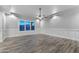 Bright, spacious bedroom with wood-style flooring, modern wainscoting, and large windows offering ample natural light at 18371 W Roma Ave, Goodyear, AZ 85395