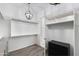 Walk-in closet with custom shelving and a modern light fixture at 18371 W Roma Ave, Goodyear, AZ 85395