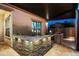 Well-equipped covered patio with granite countertop bar, barbecue grill, and storage at 18371 W Roma Ave, Goodyear, AZ 85395