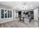 The modern kitchen features dark cabinets, stone countertops, a large island, and stainless steel appliances for a sleek, stylish look at 18371 W Roma Ave, Goodyear, AZ 85395