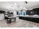 Elegant kitchen featuring stone backsplash, dark wood cabinetry, stainless steel appliances, and a spacious center island at 18371 W Roma Ave, Goodyear, AZ 85395