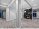 Spacious living room with tile floors and a modern fireplace with a black tiled accent wall and a decorative chandelier at 18371 W Roma Ave, Goodyear, AZ 85395