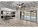 Spacious living room overlooking the pool with wood floors, tray ceiling, and access to the kitchen for seamless entertaining at 18371 W Roma Ave, Goodyear, AZ 85395