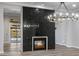 Bright living room with a fireplace, an elegant chandelier, and an open layout with easy access to the backyard at 18371 W Roma Ave, Goodyear, AZ 85395