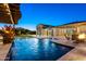 A refreshing pool with a water feature and adjacent fire pit provide a tranquil oasis for relaxing and entertaining at 18371 W Roma Ave, Goodyear, AZ 85395