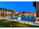 Beautiful pool with a water feature, fire pit, putting green, and outdoor seating creates an inviting backyard entertainment space at 18371 W Roma Ave, Goodyear, AZ 85395