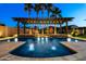 Inviting pool with a pergola and water feature, illuminated at night, perfect for relaxation and entertainment at 18371 W Roma Ave, Goodyear, AZ 85395