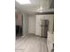 Bright kitchen area with stainless refrigerator, white cabinets and light, wood-look flooring at 2019 E Southern Ave, Phoenix, AZ 85040