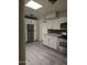 Modern kitchen boasts sleek white cabinets, stainless steel appliances, and eye catching black and white mosaic tile backsplash at 2019 E Southern Ave, Phoenix, AZ 85040