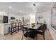 Bright dining area featuring a modern light fixture, stylish table setting, and seamless flow into the sleek, white kitchen at 2041 W Palo Verde Dr, Phoenix, AZ 85015