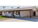 Attractive single-story home boasts a white exterior, dark trim, a neatly kept lawn, and a convenient covered parking area at 2041 W Palo Verde Dr, Phoenix, AZ 85015