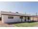 Well-maintained single-story home with a clean white exterior, dark trim, and a neatly landscaped front yard with green grass at 2041 W Palo Verde Dr, Phoenix, AZ 85015