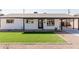 Well-kept home with a white exterior, black trim, neatly arranged landscaping, and a spacious covered parking area at 2041 W Palo Verde Dr, Phoenix, AZ 85015
