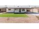 Charming home featuring a bright white exterior, dark accents, a manicured lawn, and a covered parking area for convenience at 2041 W Palo Verde Dr, Phoenix, AZ 85015