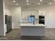 Modern kitchen with white cabinets, stainless steel appliances, an island, and wood-look floors at 231Xx W Gloria Ln, Wittmann, AZ 85361