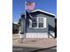 Charming mobile home with blue siding, white trim, US and Navy flags flying at 2600 E Allred Ave # R-88, Mesa, AZ 85204