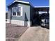Cozy mobile home featuring blue siding, white trim, and convenient covered parking at 2600 E Allred Ave # R-88, Mesa, AZ 85204