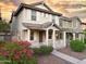 Charming two-story home featuring a cozy front porch, white railings, and beautiful, vibrant landscaping at 2947 N Evergreen St, Buckeye, AZ 85396