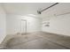 Clean, spacious garage with concrete flooring, overhead lighting, and ample storage shelves at 2947 N Evergreen St, Buckeye, AZ 85396