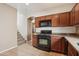 Well-lit kitchen with tiled floors, wooden cabinets, and modern appliances, next to the stairs at 2947 N Evergreen St, Buckeye, AZ 85396