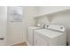 Bright laundry room includes a window, shelving, and a modern washer and dryer at 2947 N Evergreen St, Buckeye, AZ 85396