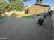 This backyard features mature landscaping, some grass, and gravel at 330 W Evergreen Pear Ave, Queen Creek, AZ 85140