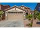 Charming single-story home with a two-car garage, stone accents, tile roof and desert landscaping in front at 33207 N Slate Creek Dr, San Tan Valley, AZ 85143