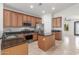 Eat-in kitchen features brown wood cabinets, stainless steel appliances, and granite countertops with central island at 33207 N Slate Creek Dr, San Tan Valley, AZ 85143