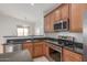 Eat-in kitchen features stainless steel appliances, granite countertops, wood cabinets, and a dining area at 33207 N Slate Creek Dr, San Tan Valley, AZ 85143