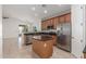 Eat-in kitchen features brown wood cabinets, stainless steel appliances, granite countertops, and central island at 33207 N Slate Creek Dr, San Tan Valley, AZ 85143