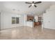 Open concept living room area featuring tile flooring, ceiling fan, a large window and kitchen access at 33207 N Slate Creek Dr, San Tan Valley, AZ 85143