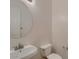 Powder room with a circular mirror above the sink and a modern toilet at 42625 W Sandpiper Dr, Maricopa, AZ 85138
