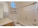 Clean bathroom with tub, shower, vanity with sink, and arched window at 42625 W Sandpiper Dr, Maricopa, AZ 85138