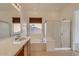 Bright bathroom featuring a soaking tub, glass shower, and vanity with a sink at 42625 W Sandpiper Dr, Maricopa, AZ 85138