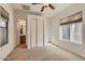 Bedroom with carpet flooring, white closets and doors, and view to bathroom at 42625 W Sandpiper Dr, Maricopa, AZ 85138