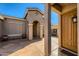 Inviting entryway with tiled porch leading to a tan-colored door at 42625 W Sandpiper Dr, Maricopa, AZ 85138