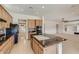 Modern kitchen with granite countertops, center island, and black appliances, perfect for cooking and entertaining at 42625 W Sandpiper Dr, Maricopa, AZ 85138
