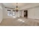 Sun-filled room with ornate chandelier, large windows and a door to the living quarters at 42625 W Sandpiper Dr, Maricopa, AZ 85138