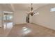 Spacious living room with natural light and a decorative chandelier at 42625 W Sandpiper Dr, Maricopa, AZ 85138