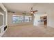 Bright living room with built-in media center, fan and views of the backyard pond at 42625 W Sandpiper Dr, Maricopa, AZ 85138